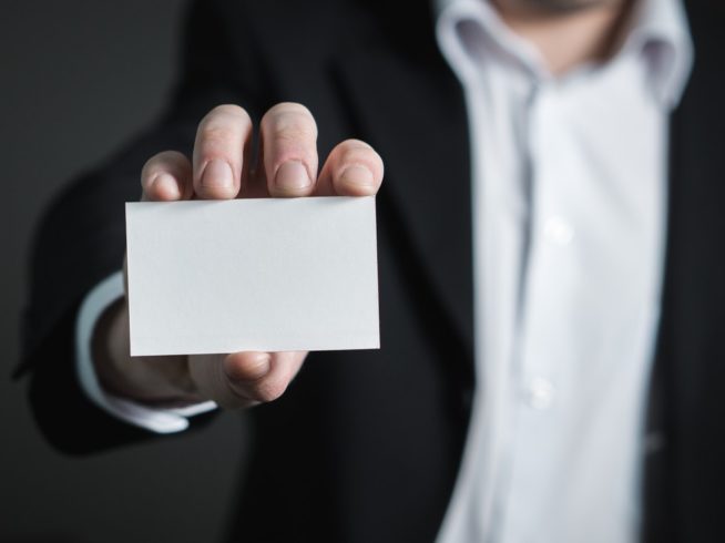 diseño de tarjetas; hombre de traje mostrando una tarjeta en blanco