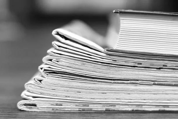 Tabloide; hombre sosteniendo una publicación de este tamaño