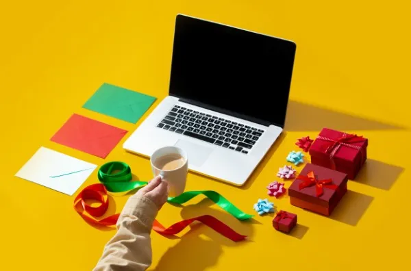 Regalos corporativos navideños junto a una laptop, resaltando el impacto positivo de estos detalles en el reconocimiento y motivación del equipo. Regalos corporativos navideños, una excelente forma de fortalecer relaciones de negocio y mejorar la lealtad de clientes y empleados.