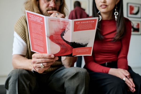 Lectura de un brochure por dos personas representado la importancia de captar la atencion de un publico objetivo.