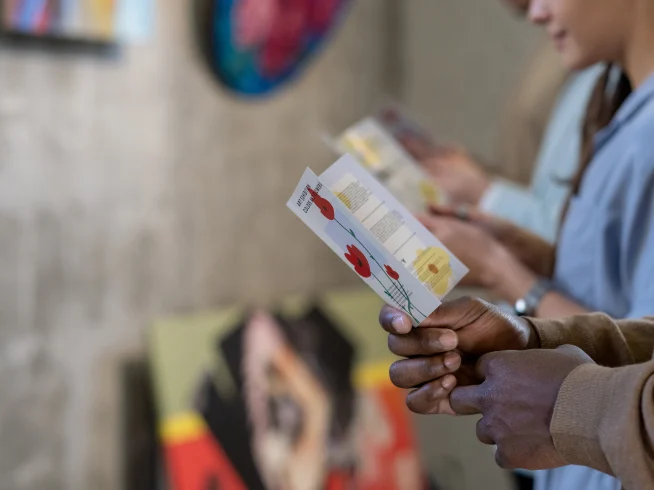 Persona sentada en una sala de espera leyendo con atención un brochure informativo que contiene detalles sobre servicios médicos y horarios de atención.