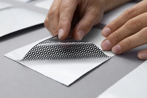 Foto de una persona despegando la impresión foil de un trabajo realizado en Impresos César.