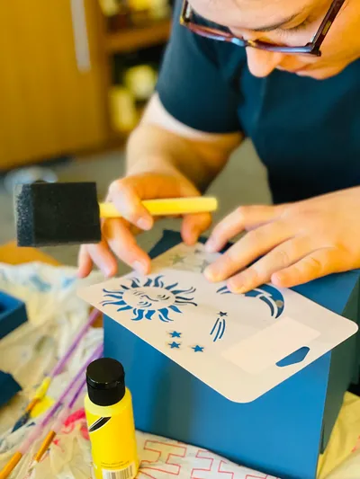 Foto de un hombre con lentes realizando el embalaje de una caja con impresión foil de color azul.
