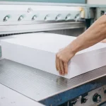 Proceso de corte y acomodo de pliegos de gran tamaño, utilizado para explicar qué es el formato tabloide dentro de los flujos de impresión comercial y editorial.
